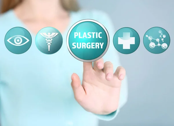 Donna che preme il pulsante SURGERY PLASTICO sullo schermo virtuale — Foto Stock