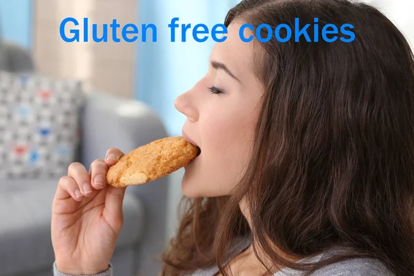 Junge Frau beim Keksessen. Text glutenfreie Cookies auf Hintergrund — Stockfoto