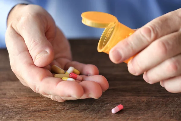 Sênior mãos segurando pílulas — Fotografia de Stock