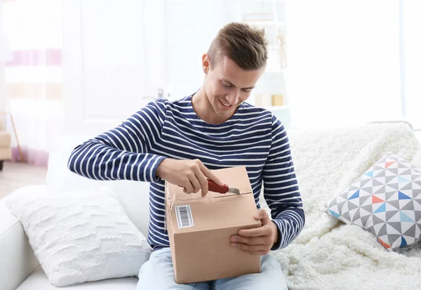 Joven desempacando paquete —  Fotos de Stock