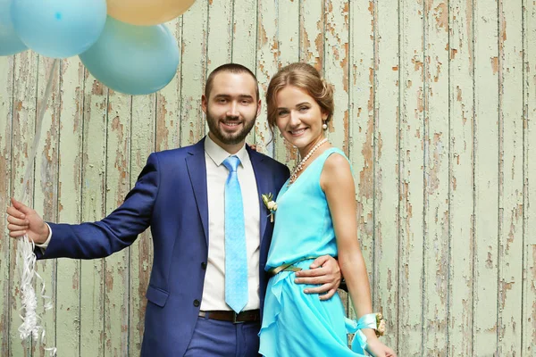 Portrait of bridesmaid and best man with balloons on wooden background
