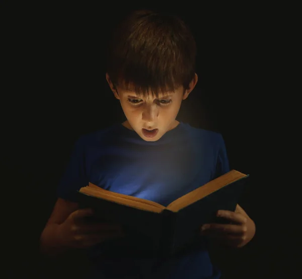Cute Chłopiec Czytanie Książki Ciemności — Zdjęcie stockowe