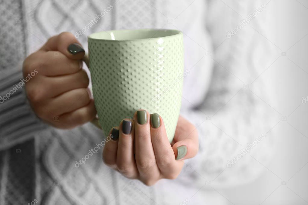 Female hands holding cup