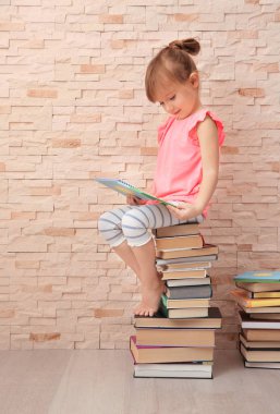Küçük kız kitap okuyor.