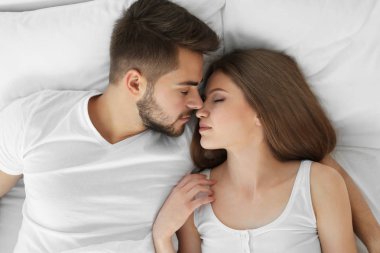 Genç çift yatakta yatıyor. 