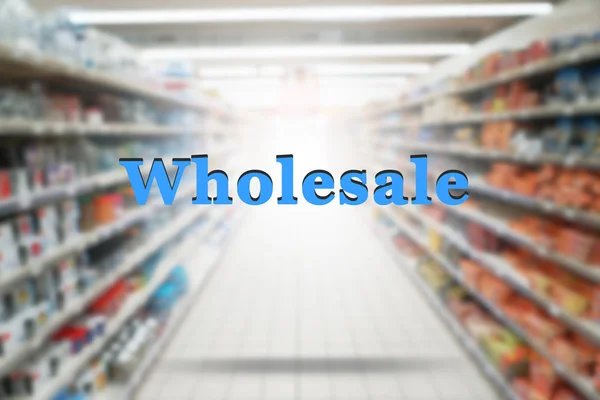 Word WHOLESALE on blurred supermarket