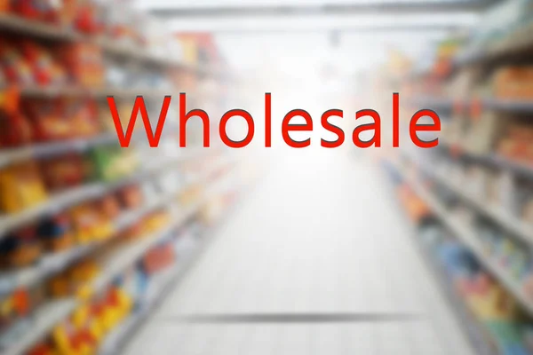 Word WHOLESALE on blurred supermarket