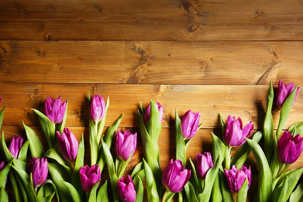 Mooie bloemen op houten tafel — Stockfoto