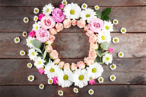 Hermosas flores sobre mesa de madera — Foto de Stock