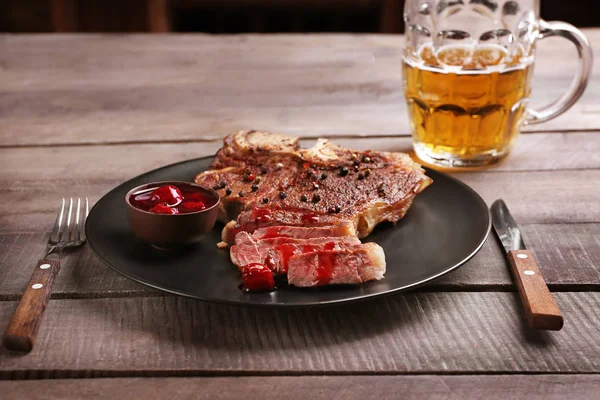 Grilovaný steak na talíř a hrnek piva — Stock fotografie