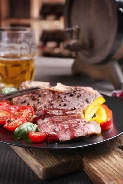 Grilovaný steak s čerstvou zeleninu na talíř a hrnek piva — Stock fotografie