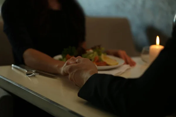 Paar gibt sich im Restaurant die Hand — Stockfoto