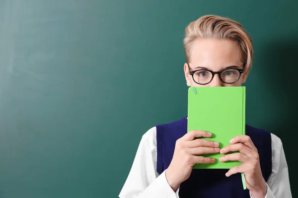 Leerling met boek in de buurt van blackboard — Stockfoto