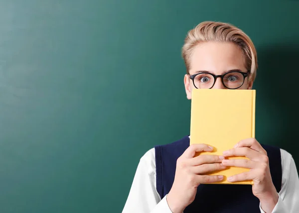 Leerling met boek in de buurt van blackboard — Stockfoto