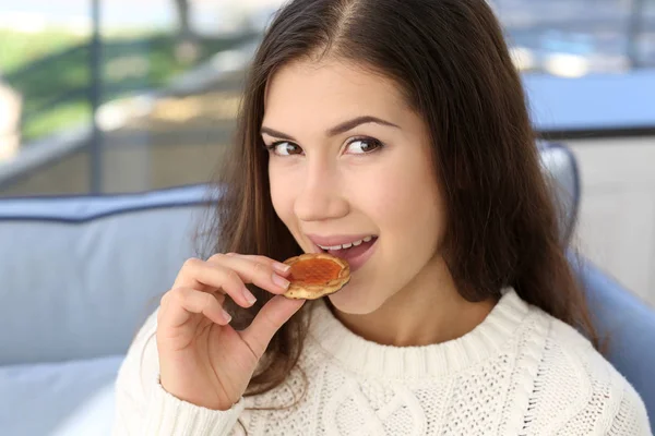 Mujer comiendo sabrosa galleta —  Fotos de Stock