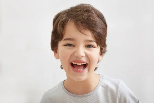 Bonito emocional pequeno menino no luz desfocado fundo — Fotografia de Stock