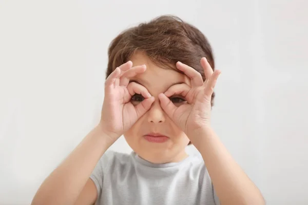 Schattige emotionele kleine jongen op licht onscherpe achtergrond — Stockfoto