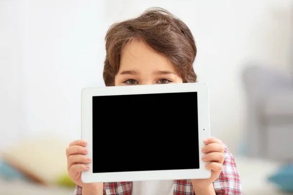 Lindo niño emocional con la tableta en el fondo borroso luz — Foto de Stock