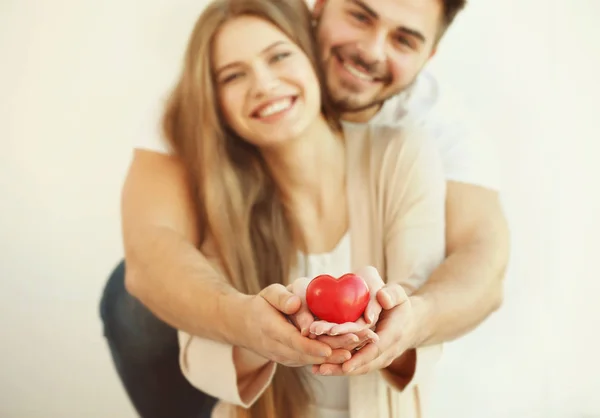 Casal Jovem Segurando Pequeno Coração Vermelho Fundo Claro — Fotografia de Stock