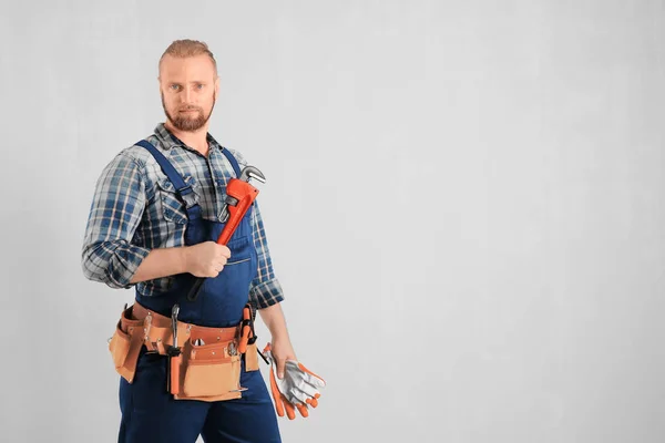 Handsome plumber with pipe wrench — Stock Photo, Image