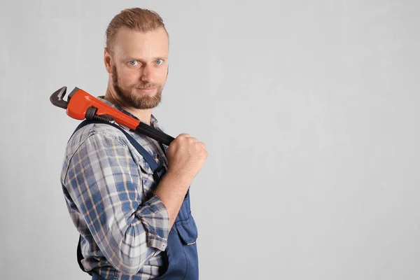 Knappe loodgieter met pipe wrench — Stockfoto