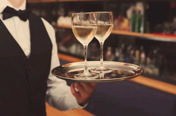 Официант держит поднос с бокалами для вина — стоковое фото