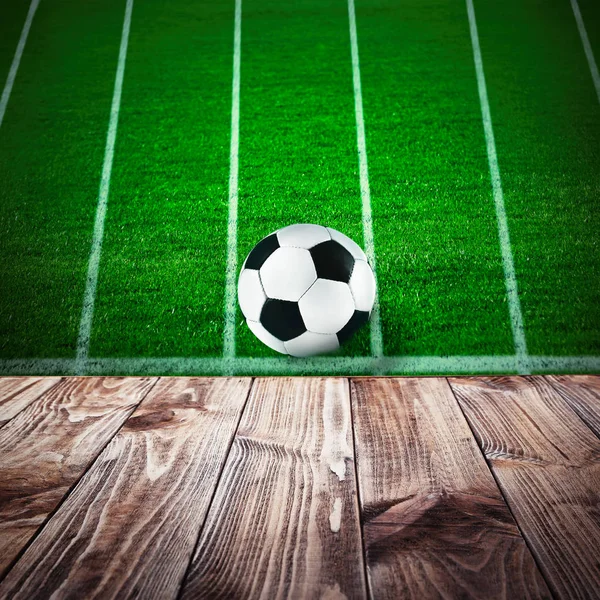 Wooden table against football field — Stock Photo, Image