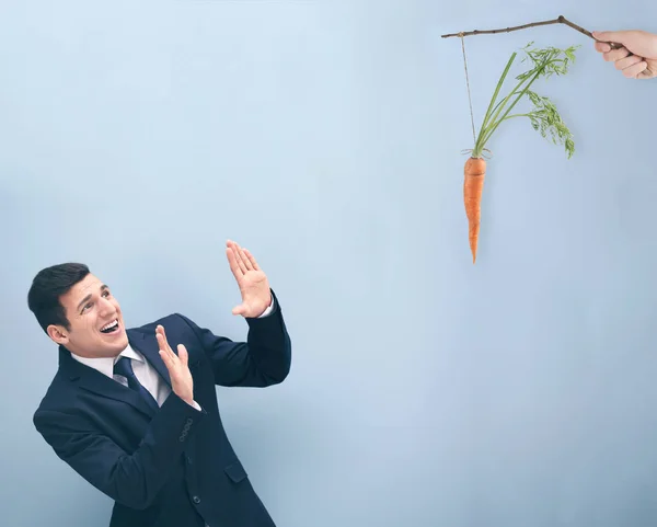 Мотивация Концепция Цели Молодой Человек Смотрит Морковь Цветной Фон — стоковое фото