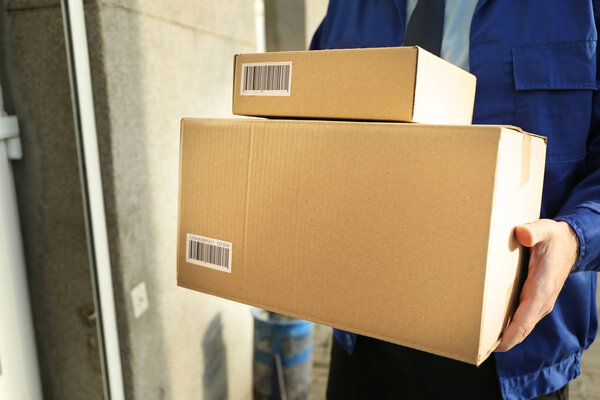 Курьер с посылками на улице
