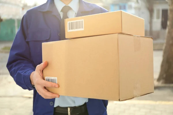 Courier met percelen buitenshuis — Stockfoto