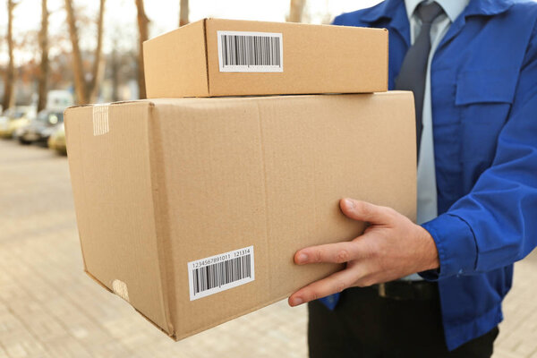 Курьер с посылками на улице
