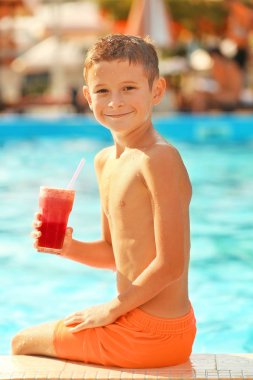 Güneşli yüzme havuzunda kokteyl ile küçük çocuk