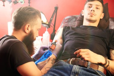 Profesyonel sanatçı kuaförde dövme yapıyor.