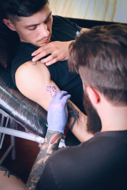 Profesyonel sanatçı kuaförde dövme yapıyor.