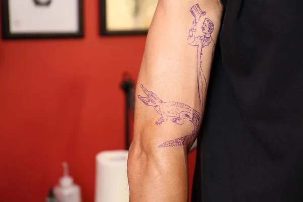 Male arm with applied tattoo sketch, close up view