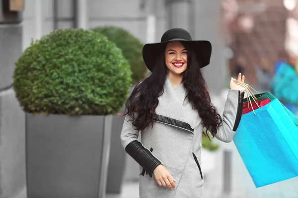 Schönes Mädchen mit Einkaufstüten auf der Straße — Stockfoto