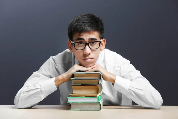 Estudiante con libros sentados a la mesa —  Fotos de Stock