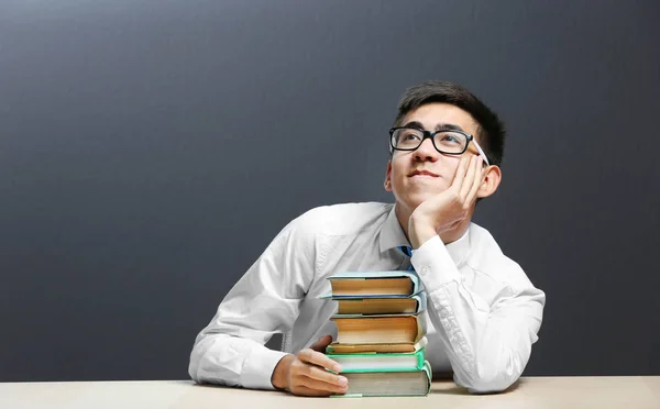 Estudiante con libros sentados a la mesa —  Fotos de Stock