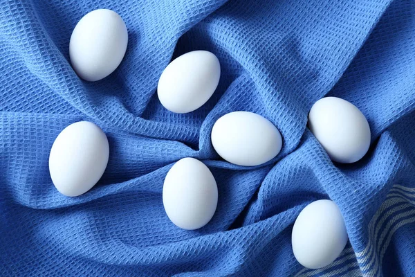 Surowe jaja na niebieskiej tkaniny — Zdjęcie stockowe
