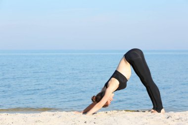  Deniz tarafından yoga yaparken kadın