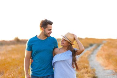 Bir çayırda yürüyen genç mutlu çift