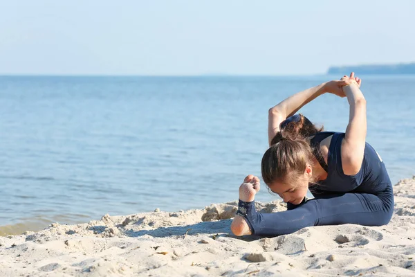 Mujer haciendo yoga por mar — Foto de Stock