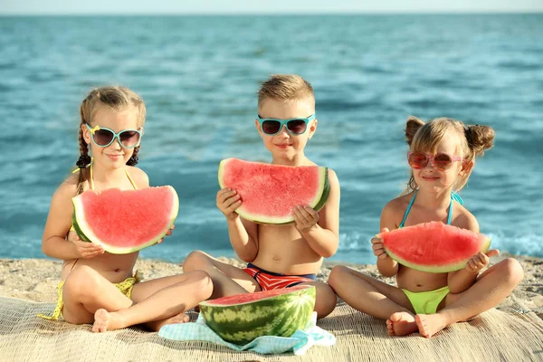 해변에 수 박 먹는 귀여운 아이 — 스톡 사진