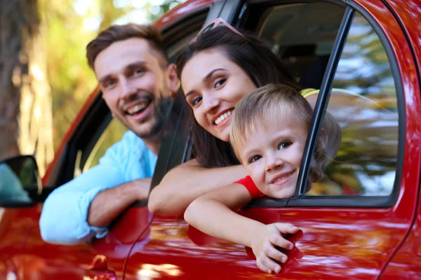 Keluarga bahagia dengan anak duduk di mobil pada hari yang cerah — Stok Foto