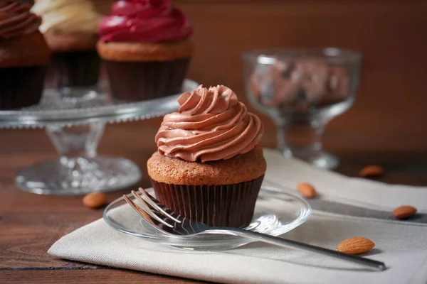 Plate with tasty cupcake, fork and napkin — Stock Photo, Image