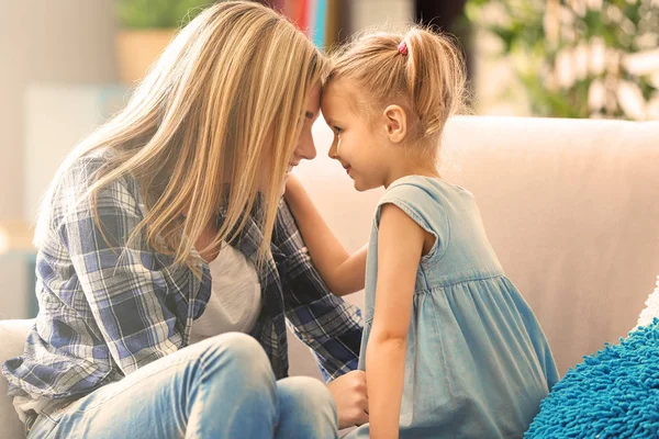 美丽的年轻女子和她的女儿坐在沙发上在家 母亲节概念 — 图库照片