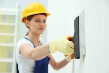 Genç bir kadın işçi yapım onarım odasında