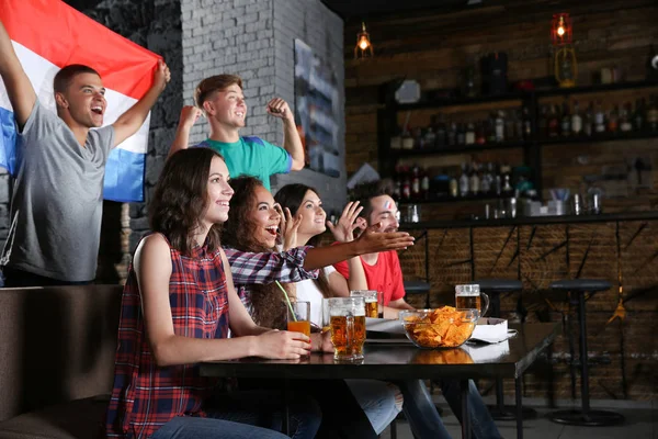 スポーツ バーでサッカーの試合を見て感情的にフランスの国旗と陽気な友達 — ストック写真