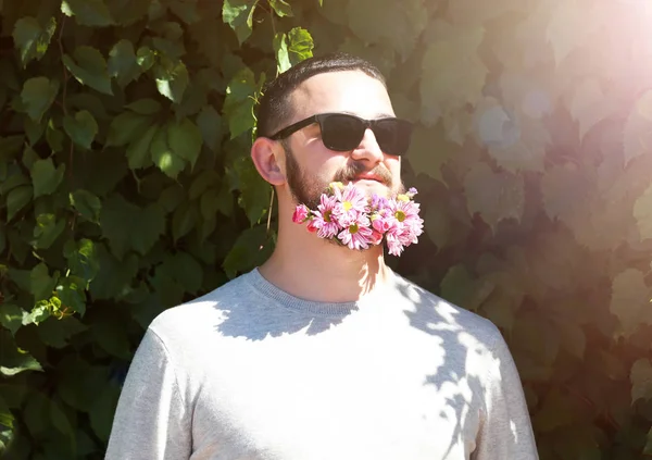 Όμορφος άνδρας σε γυαλιά ηλίου με γενειάδα λουλούδια — Φωτογραφία Αρχείου
