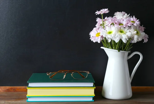 Bukett blommor, böcker med glasögon — Stockfoto